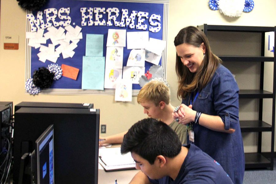 Mrs. Hermes assists Craig Smith (12) and Ethan Jordan (11) in her Dollars and Sense class.